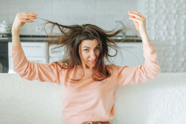 脏兮兮的头发蓬乱的年轻女人，有趣的快乐的女孩与蓬乱的长发图片下载