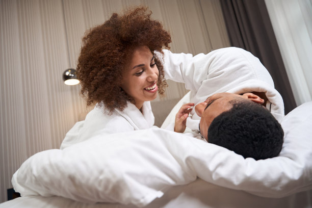 一对幸福的情侣懒洋洋地躺在旅馆的床上图片下载