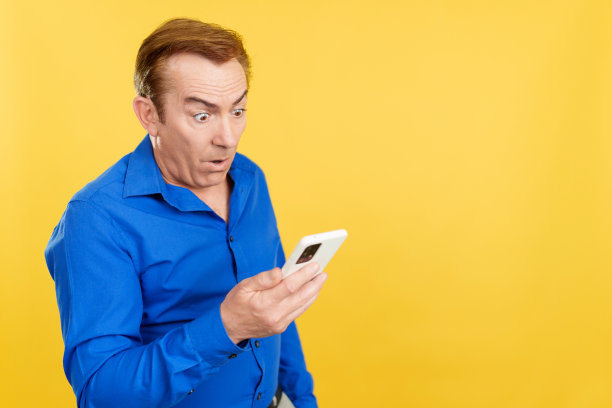 惊讶的成熟男人看着手机图片下载