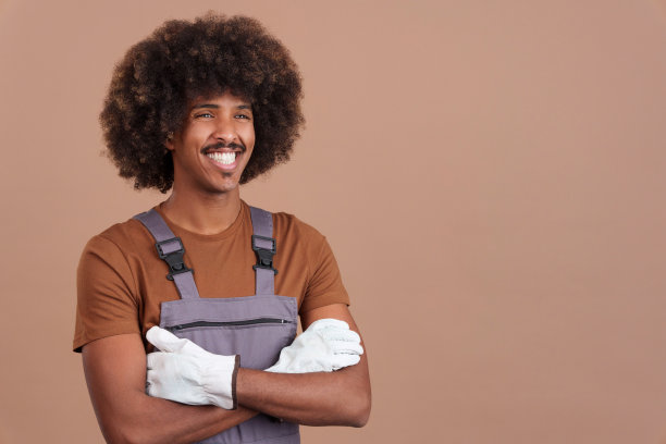 微笑的非洲人木工工人与工具和工作制服图片下载