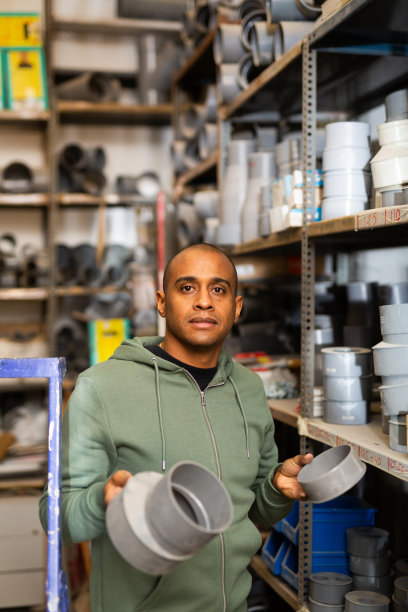 细心的男子在五金店购买管道塑料配件图片下载