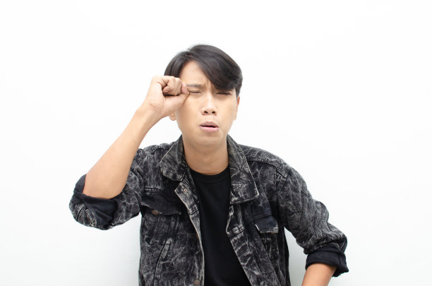 在白色的背景下，一个穿着牛仔夹克、哭着的年轻亚洲男子被孤立了图片下载