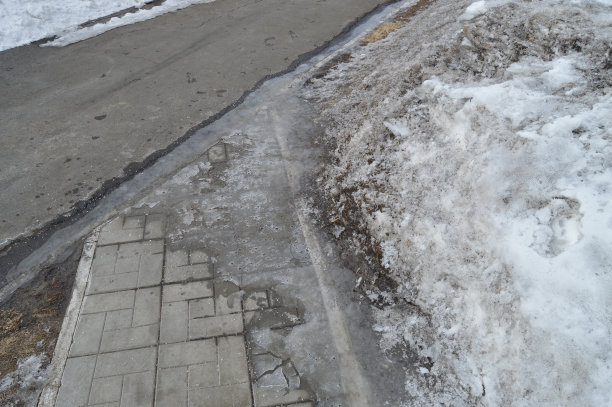 公园里的人行道十字路口，路边的积雪，春天的背景带着复制的空间图片下载