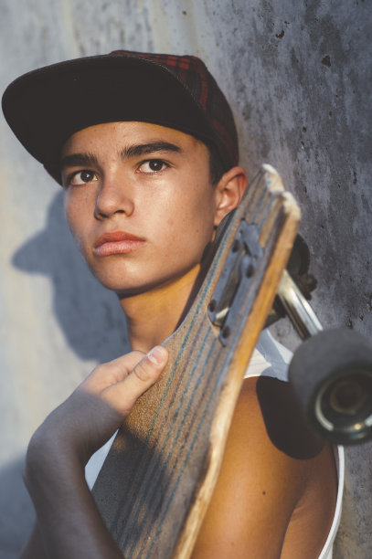 男孩滑冰摆着滑板。图片下载