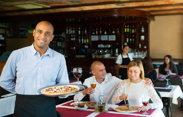 好客的拉丁美洲服务员在披萨餐厅欢迎客人图片下载