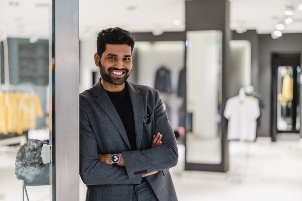 微笑的店主站在服装店门口图片下载