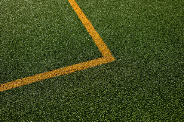 运动场有绿色合成草和白黄线。橄榄球，橄榄球，足球，棒球概念图片下载