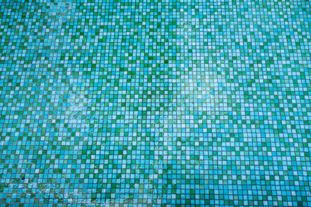 泳池的地板是由绿色和蓝色的小方形瓷砖制成的，从上面看，表面有冰的痕迹。图片下载