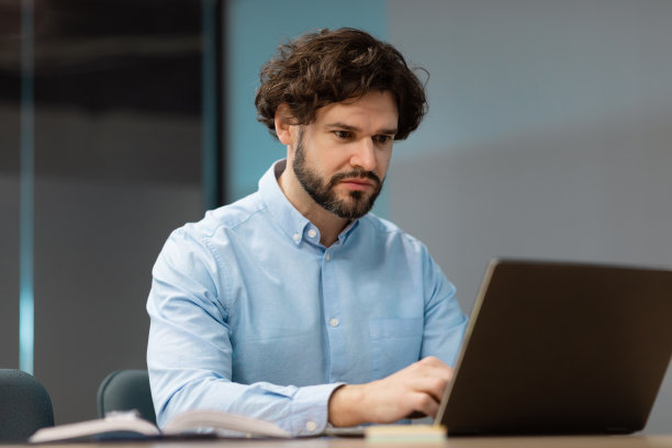 商务人士坐在办公室的椅子上使用笔记本电脑图片下载