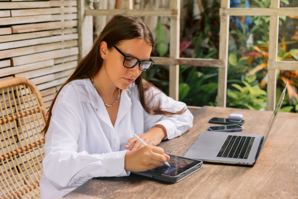女设计师在夏季办公室使用平板电脑和笔记本电脑图片下载