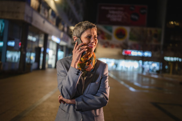 大妈晚上在城里用手机打电话图片下载