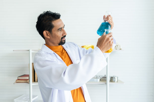 科学教师学校，拿着烧瓶做实验，拿着两个不同颜色的烧瓶，比较它们是否得到想要的颜色，准备教孩子们在科学课上做化学实验。图片下载