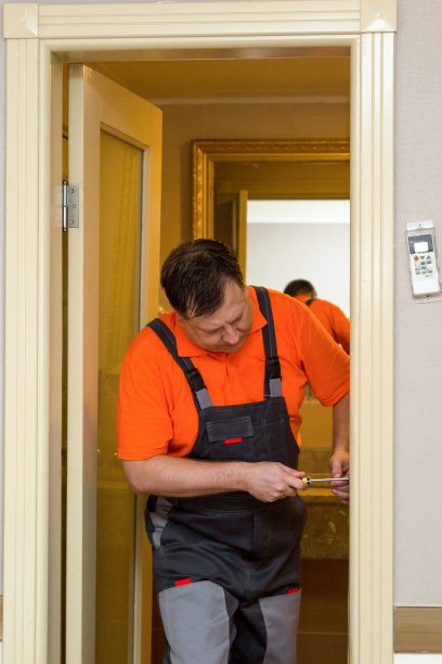 穿着工作服的男人正在修门上的锁图片下载