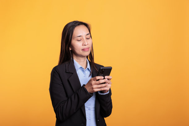 亚洲妇女拿着手机发短信图片下载