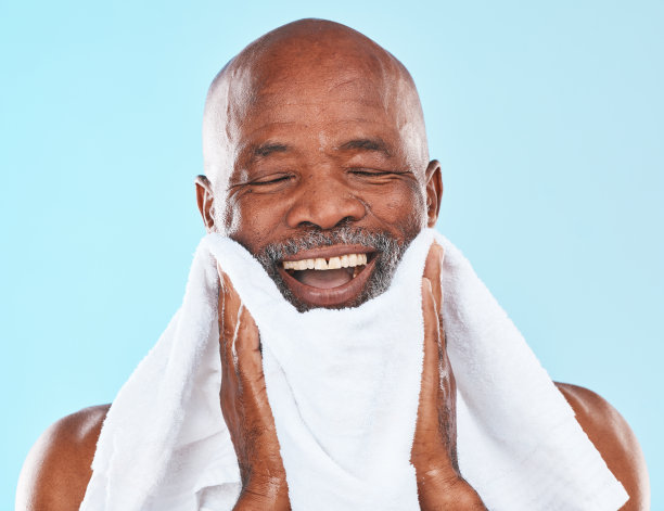 黑人，工作室和毛巾剃须，微笑和自我保健，卫生和胡子由蓝色背景。老年男子，快乐和布为护肤，健康和仪容仪表例行的背景图片下载