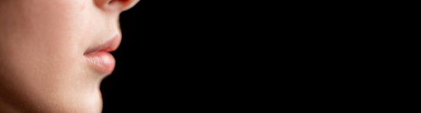 在黑色背景的十几岁女孩的侧面脸的下半部分。横幅，文本空间。心理帮助，青少年观念支持。图片下载