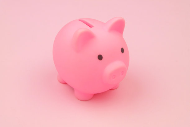 粉红色背景上的粉红色储蓄罐特写图片下载