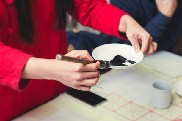 中国书法课，孩子们在课堂上学习和练习传统书法，孩子们在学校里学习墨笔字图片下载