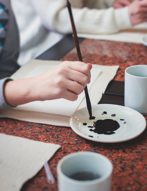 中国书法课，孩子们在课堂上学习和练习传统书法，孩子们在学校里学习墨笔字图片下载