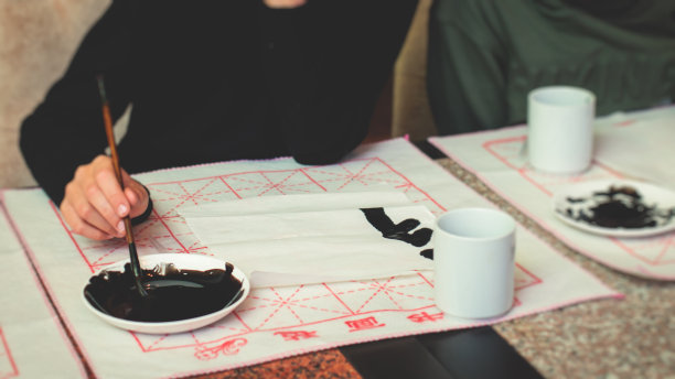 中国书法课，孩子们在课堂上学习和练习传统书法，孩子们在学校里学习墨笔字图片下载