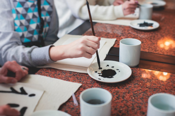 中国书法课，孩子们在课堂上学习和练习传统书法，孩子们在学校里学习墨笔字图片下载