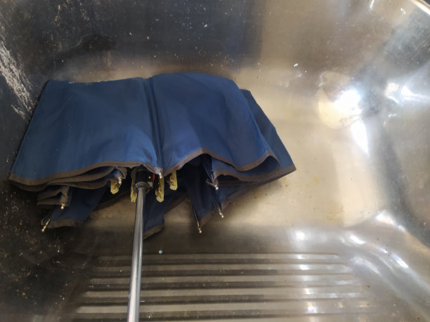 一把蓝色的雨伞在空水槽里晾干图片下载