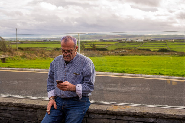 随着年龄的增长，眼科问题开始出现，需要用眼镜看手机。图片下载