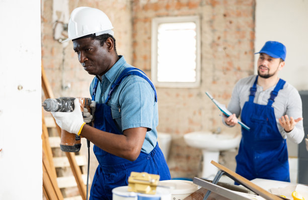 工头告诉建筑工人用冲击钻在哪里钻孔图片下载