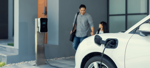 聚焦进步电动汽车在家里与模糊的父亲和他的女儿在背景图片下载