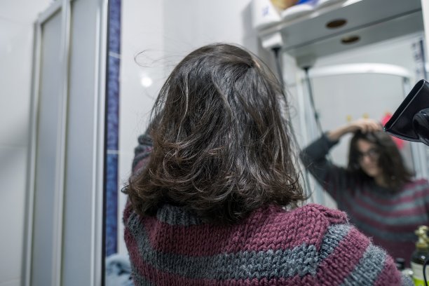 一个在浴室里吹头发的少女的背影图片下载