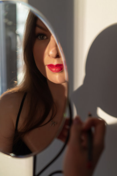 一个穿着黑裙子，涂着红唇的年轻女子。图片下载