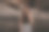 一张海滩照片，一个美丽的性感的年轻女子，黑色长发，穿着裙子，在海滩上的巨石旁摆姿势。图片下载