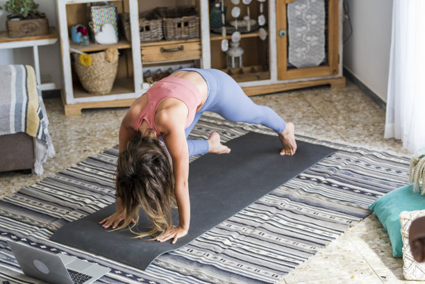 年轻女子锻炼在家做俯卧撑和使用在她的个人笔记本电脑学习或教锻炼内容创建者商业免费健康生活方式的人的概念图片下载