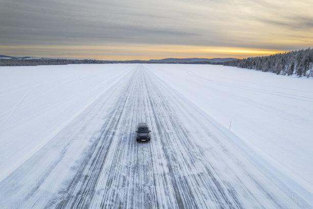 在结冰的湖面上行驶在冰路上的汽车图片下载