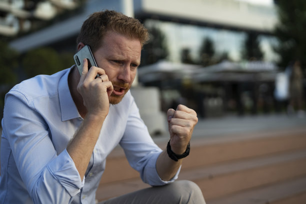 愤怒不安的男人对着电话说话图片下载