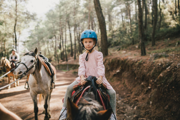 年轻女孩骑马穿过风景如画的地方。图片下载