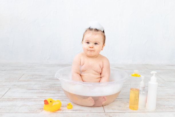 婴儿洗面奶放在有泡沫的碗里，奶瓶上有文字的空间，婴儿卫生图片下载