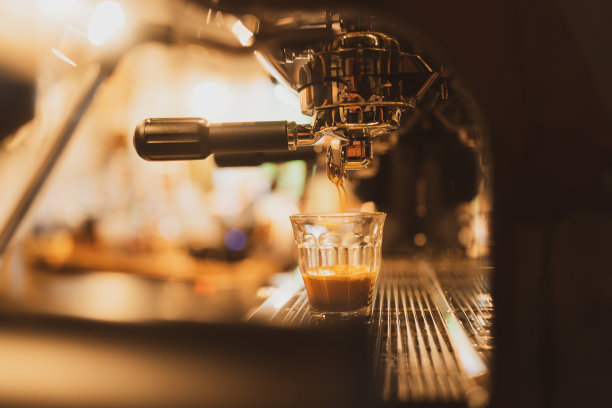 图为，上午在咖啡店内，职员们正在从专业咖啡机中提取咖啡。咖啡师用深杯专业提取咖啡的“特写咖啡机”图片下载