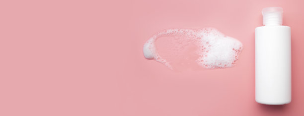 化妆品模板模型。白色塑料瓶，粉红色背景上有空气泡沫。洗面奶，摩丝，肥皂，洗发水，沐浴露。美容、spa、护肤、化妆品顶视图平铺图片下载