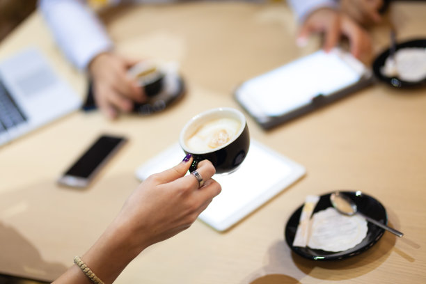 同事们在咖啡厅开会。喝咖啡，在笔记本电脑和平板电脑上工作。图片下载