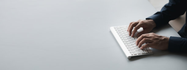 一个人在电脑键盘上打字，一个商人在一家初创公司的办公室工作，他正在给他的同事们发送信息，并制作总结会议的财务文件。副本的空间。图片下载