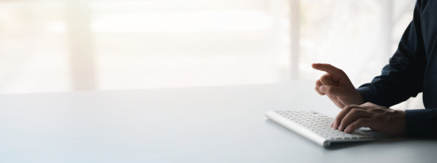 一个人在电脑键盘上打字，一个商人在一家初创公司的办公室工作，他正在给他的同事们发送信息，并制作总结会议的财务文件。副本的空间。图片下载