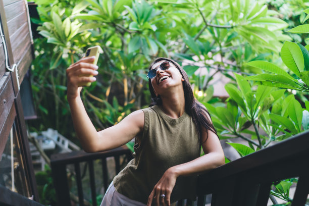 乐观的女子在度假胜地的楼梯上自拍图片下载