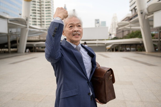 快乐的高级商人庆祝现代城市项目的成功图片下载