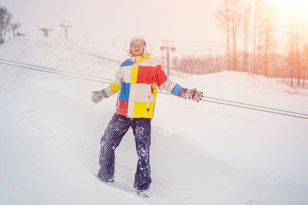 一个男人在外面扔雪，享受冬天图片下载