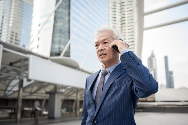 亚洲高级、成熟、中年商人在现代城市使用智能手机图片下载