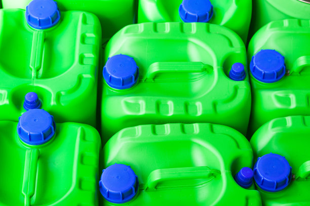 蓝色盖子的绿色塑料瓶，用来储存化学液体、燃料和润滑剂，特写。图片下载