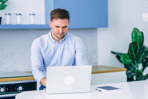 专注的年轻人在工作过程中在家。自由磨破图片下载