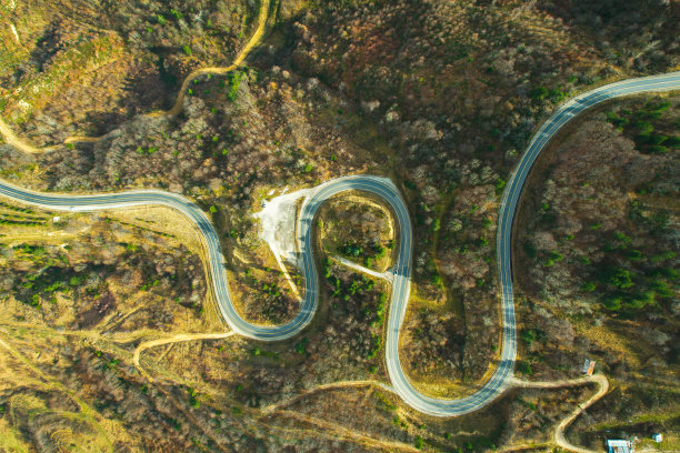 蜿蜒的山路在树木繁茂的地区。生态方法图片下载