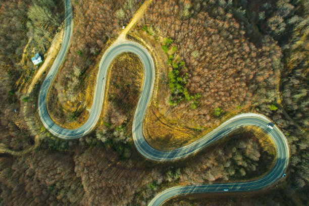 蜿蜒的山路在树木繁茂的地区。生态方法图片下载